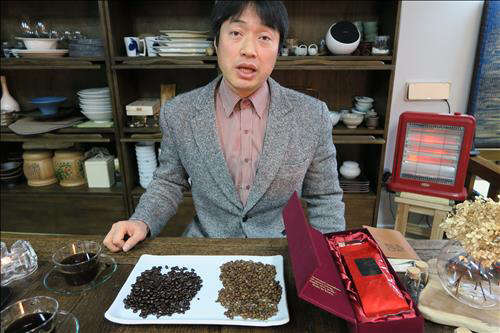 다원해삼 권강순 대표가 한잔에 8만원꼴인 '발효해삼커피'에 관해 설명하고 있다. 접시에 놓인 두가지 커피 원두 중 오른쪽이 수정을 이용한 특수기계로 원두의 껍질이 살아있도록 볶은 뒤 발효시킨 해삼추출액으로 코팅한 것이다. 왼쪽의 검은 색 원두는 시중 커피점에서 쓰는 것이다. 이 회사는 해삼을 즐겨먹은 중국의 상류층을 이 커피의 주 구매대상으로 삼고 수출을 추진하고 있다.